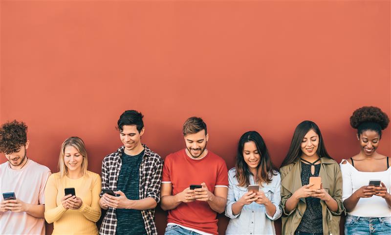 Grupa młodych ludzi korzystających ze smartfonów
